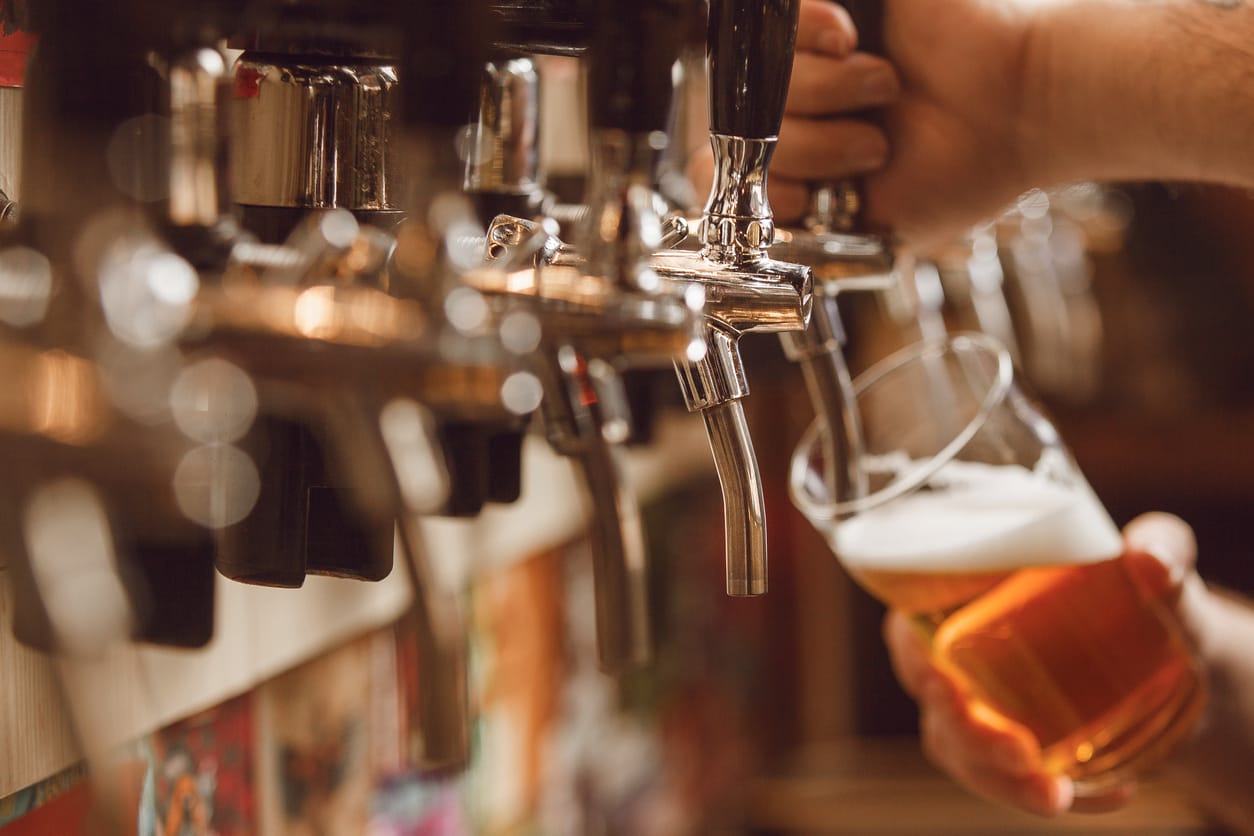 A bartender pouring a beer from the tap