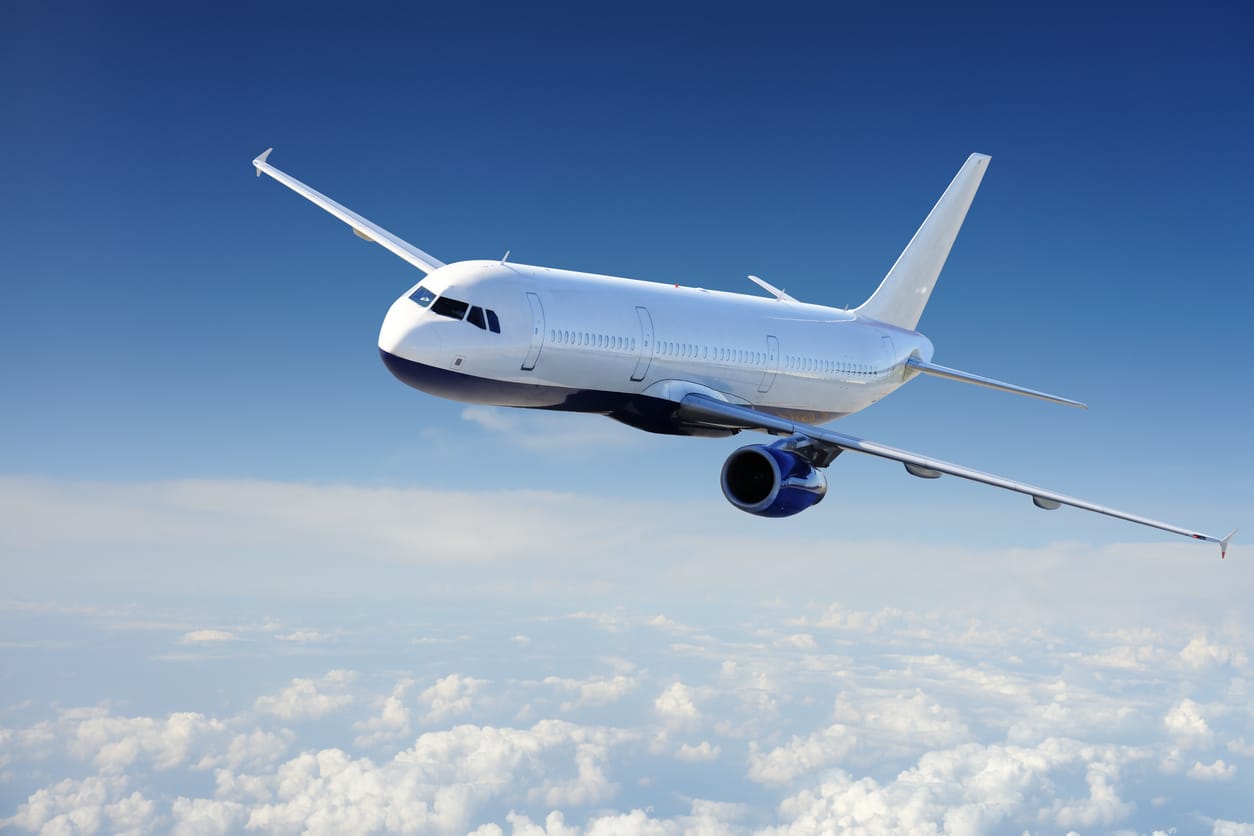 A passenger jet flying above the clouds