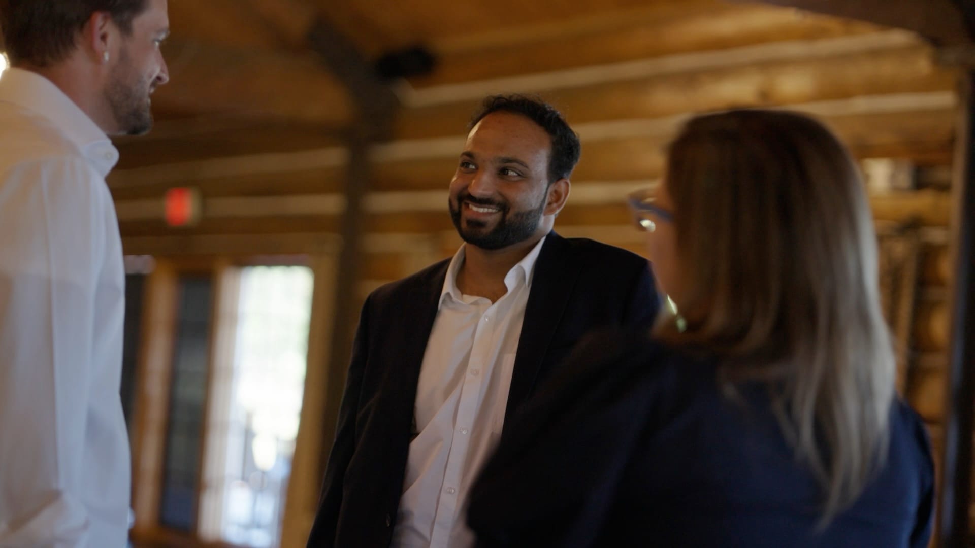 Three team members talking and laughing in the lodge