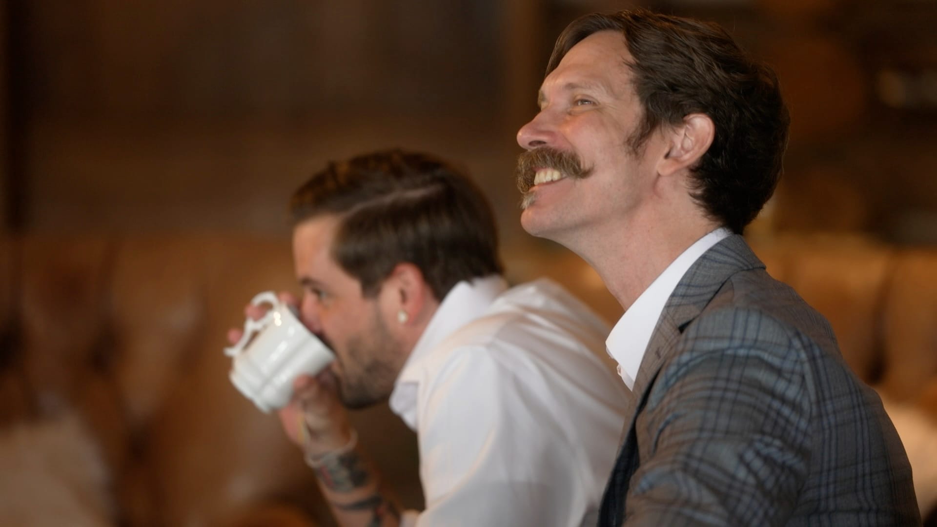 Two team members sharing a laugh over coffee