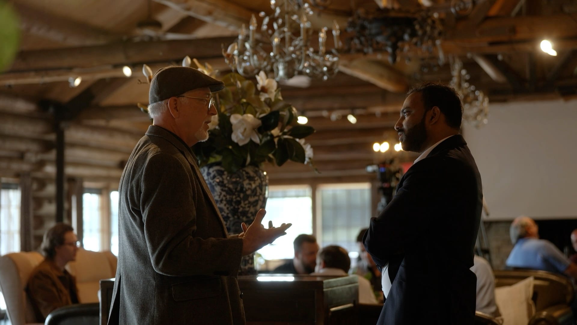 Wayne Rachel and Charles John talking in the lodge during the 2026 all-hands