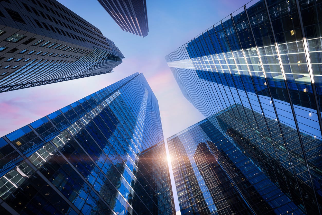 Looking up at glass office towers against the sky