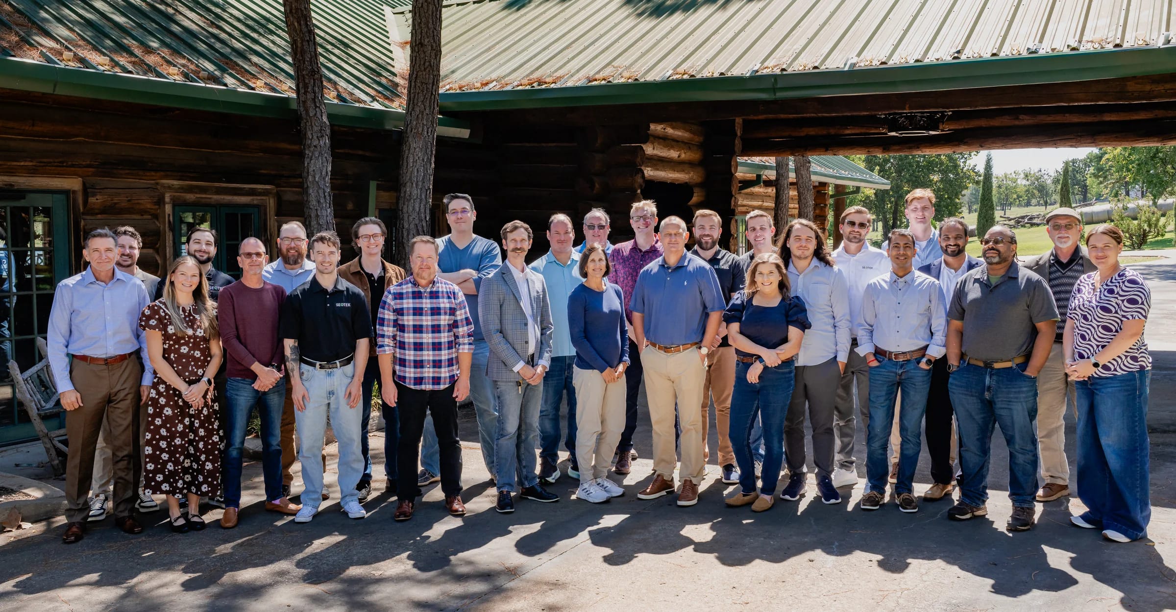 The SEQTEK team together outside a log lodge at the September 2026 all-hands